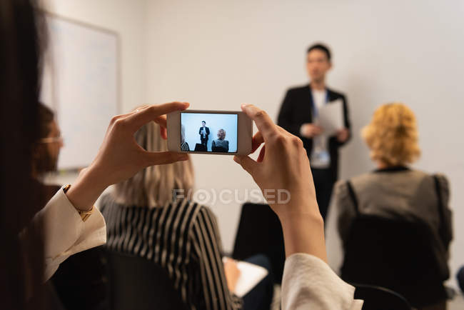Führungskraft fotografiert mit Handy im Büro — Stockfoto