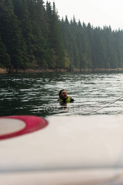 Mid adult man swimming in water after fall from wakeboard in river — Stock Photo