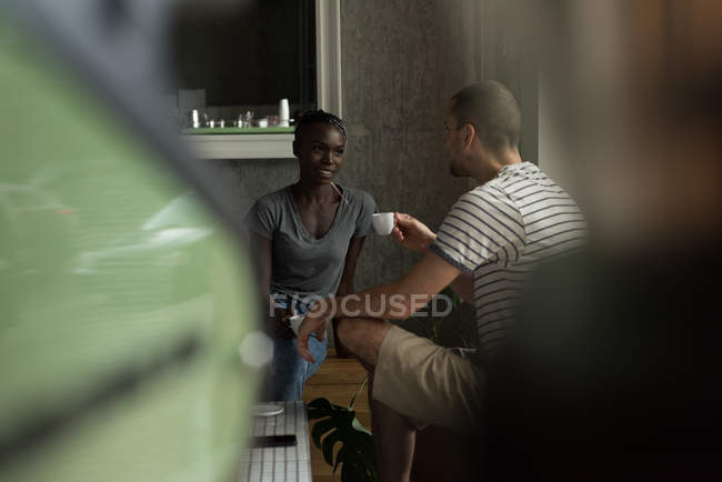 Casal conversando uns com os outros enquanto toma café no café — Fotografia de Stock