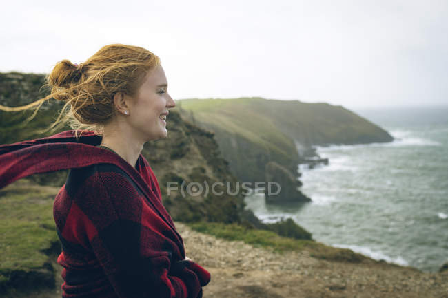Продумана руда жінка стоїть на пляжі . — стокове фото