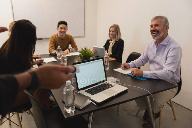 Усміхнені керівники обговорюють в залі засідань в офісі — стокове фото