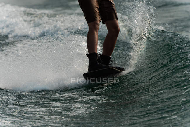 Baixa seção de wakeboarding homem na água do rio — Fotografia de Stock
