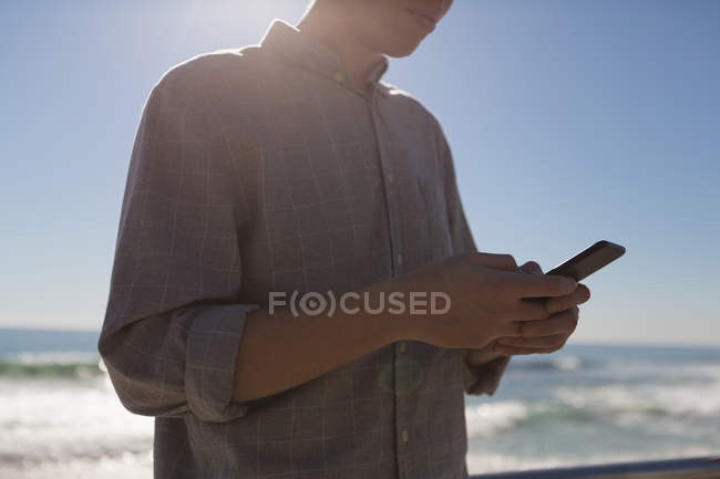 Milieu de la section de l'homme en utilisant un téléphone mobile près de la plage — Photo de stock