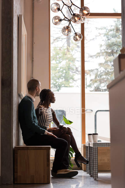 Jovem casal olhando através da janela no café — Fotografia de Stock