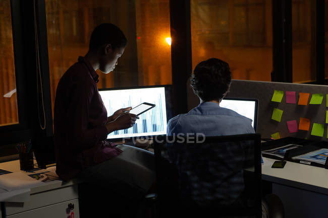 Руководители, работающие за столом в офисе ночью — стоковое фото
