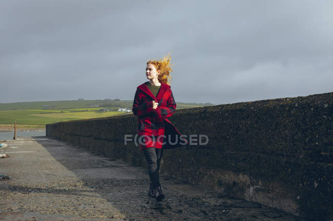 Задумчивая рыжая женщина, гуляющая по пляжу . — стоковое фото