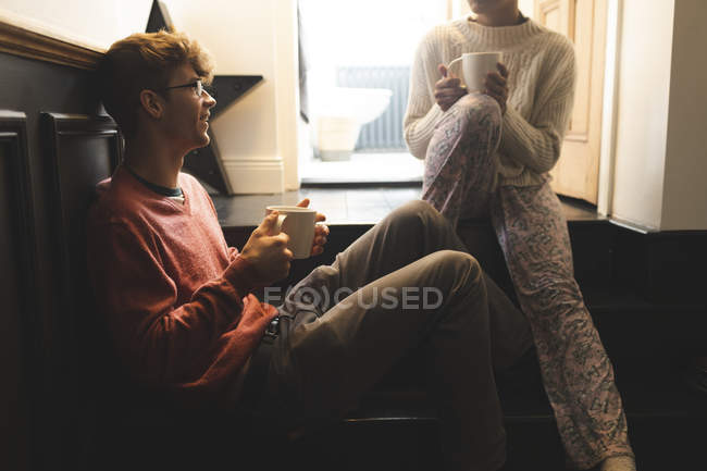 Пара взаимодействует друг с другом за чашечкой кофе дома — стоковое фото