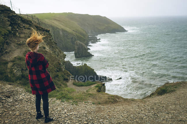 Задній вид руда жінка, стоячи біля пляжу в Ірландії. — стокове фото