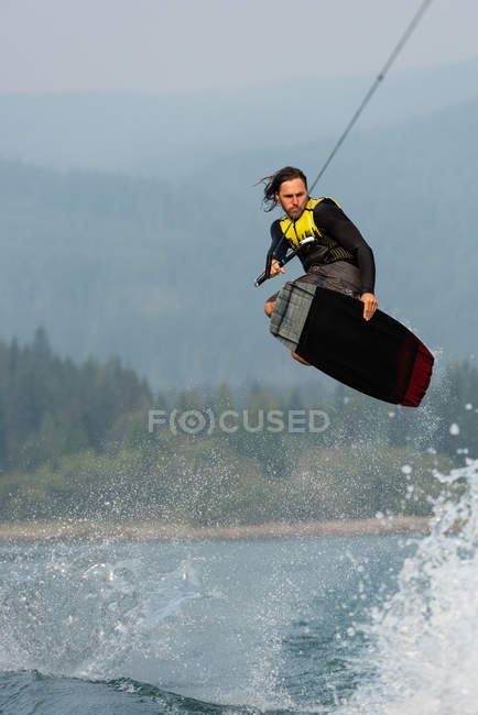 Extreme male athlete wakeboarding in river water — Stock Photo