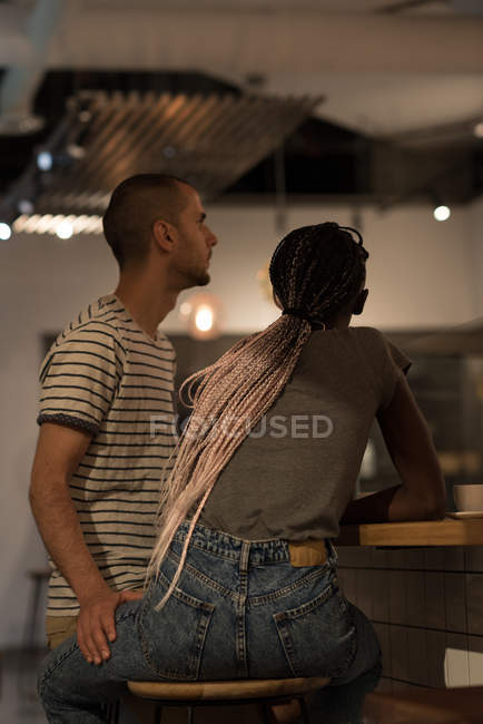 Couple sitting at table and looking away in cafe — Stock Photo