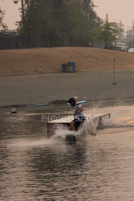 Взрослый мужчина на вейкборде в реке — стоковое фото