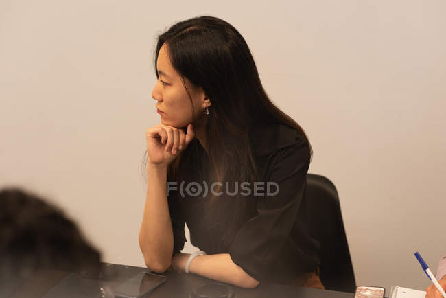Weibliche Führungskraft sitzt auf Stuhl im Konferenzraum im Büro — Stockfoto