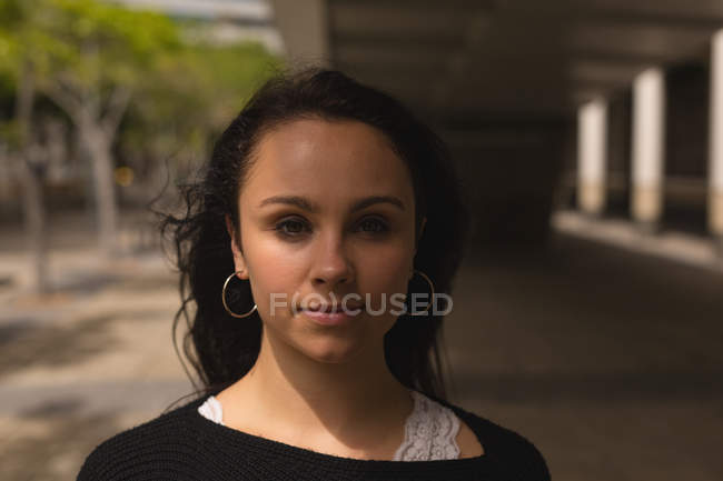 Портрет молодої жінки, що дивиться в камеру на міській вулиці . — стокове фото