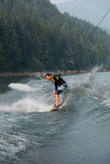Homme wakeboarder équitation vagues de la rivière des bois — Photo de stock
