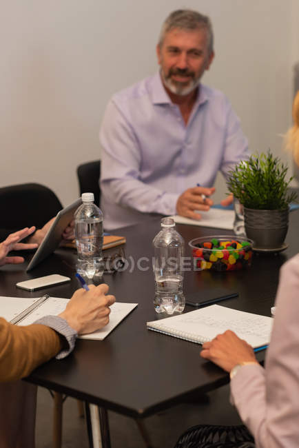 Führungskräfte schreiben auf Notizblock im Besprechungsraum im Büro — Stockfoto