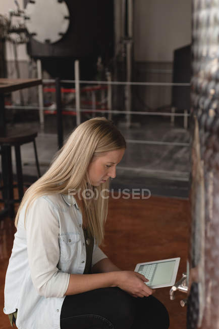 Jovem trabalhadora usando tablet digital na fábrica — Fotografia de Stock