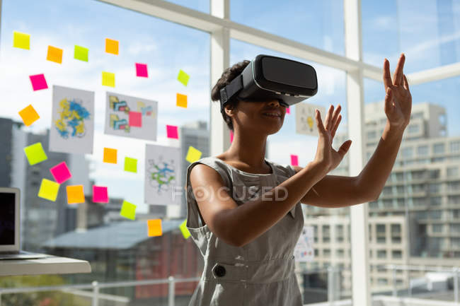 Female business executive using virtual reality headset in office. — Stock Photo