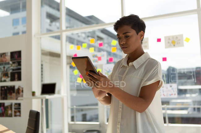 Ejecutiva femenina usando tableta digital en la oficina . - foto de stock