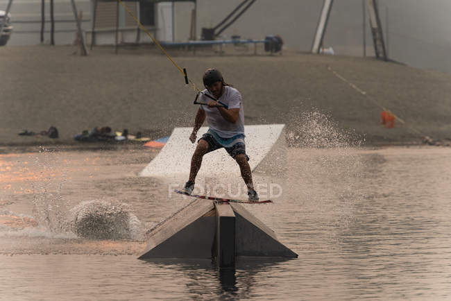 Mitte erwachsener Mann beim Wakeboarden im Flusswasser — Stockfoto