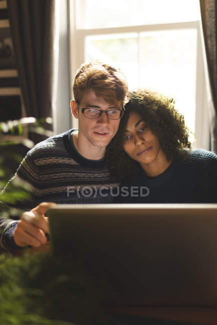 Giovane coppia utilizzando il computer portatile a casa — Foto stock