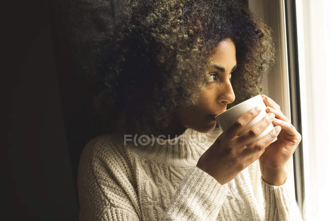 Young woman having coffee at home — Stock Photo