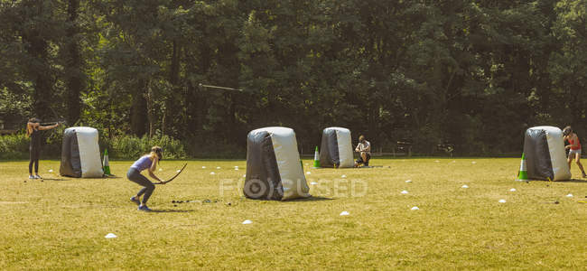 Hommes et femmes pratiquant le tir à l'arc au camp d'entraînement au soleil — Photo de stock