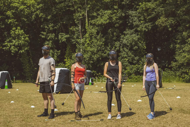 Groupe de personnes s'entraînant au tir à l'arc au camp d'entraînement en plein soleil — Photo de stock