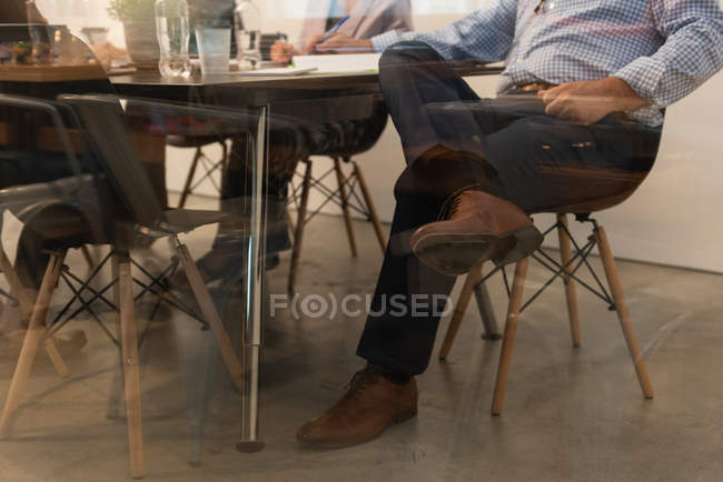 Low section of executive sitting on chair in conference room at office — Stock Photo