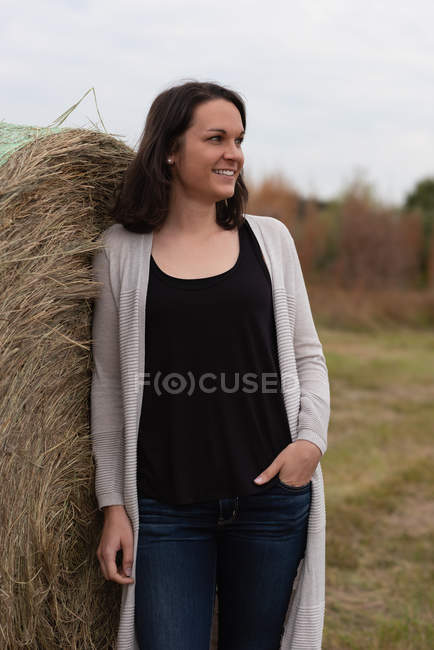 Frau lehnt und posiert auf Heuballen im Feld — Stockfoto