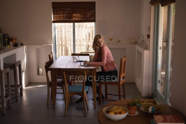 Donna premurosa che utilizza il computer portatile a casa — Foto stock