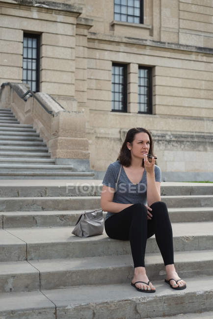 Woman talking on mobile phone in the city on a sunny day — Stock Photo