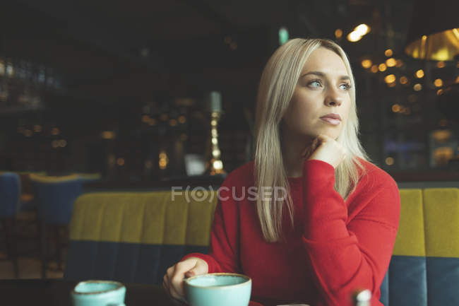 Nachdenkliche Frau schaut in Cafeteria weg — Stockfoto