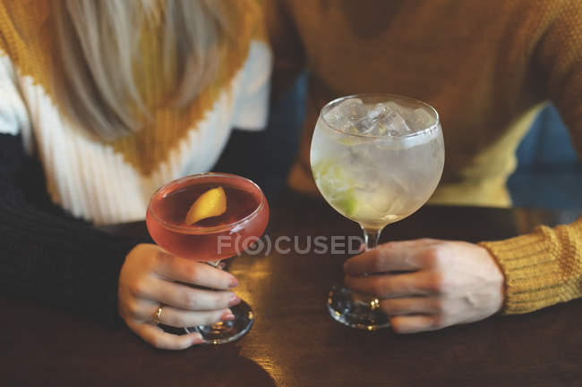 Close-up of couple holding cocktail glass in restaurant — Stock Photo