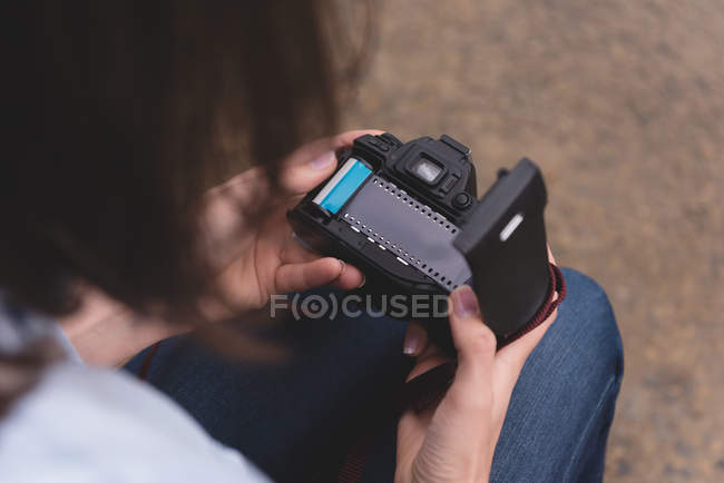 Partie médiane de la femme regardant la bobine de la caméra près du lac — Photo de stock