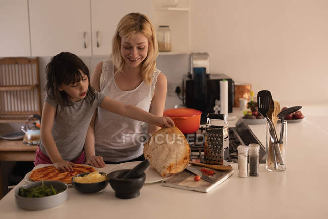 Mother and daughter preparing food in kitchen at home — Stock Photo