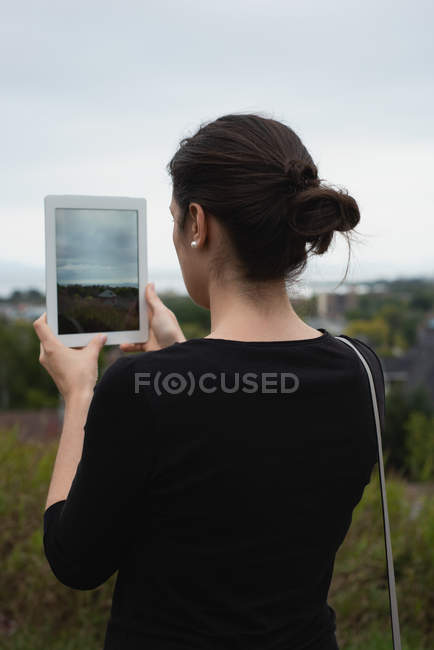 Rear view of woman clicking photos with digital tablet — Stock Photo