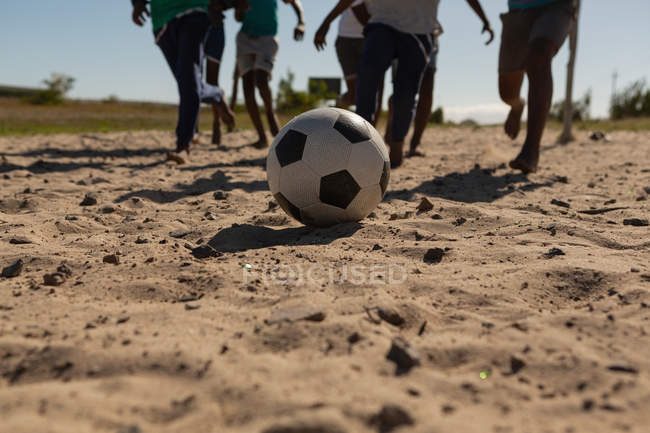 Kinder spielen an einem sonnigen Tag Fußball im Boden — Stockfoto
