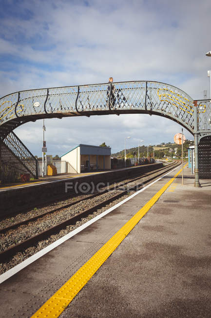 Mulher grávida andando na ponte na estação ferroviária — Fotografia de Stock