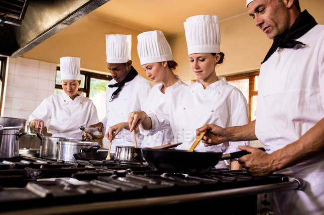 Gruppe von Köchen bereitet Essen in der Küche zu — Stockfoto
