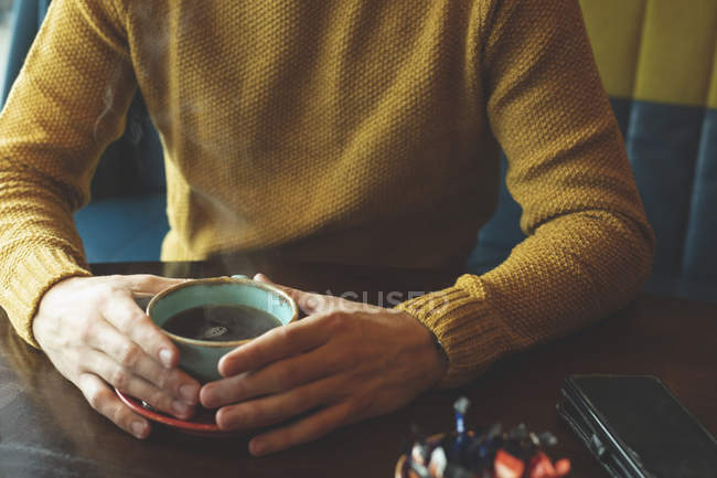 Средняя часть мужчины держит чашку кофе в кафе — стоковое фото