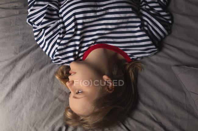 Femme se détendre sur le lit dans la chambre à coucher à la maison — Photo de stock