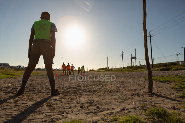 Kids playing football in the ground on a sunny day — Stock Photo