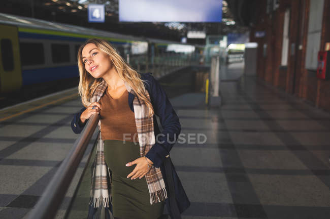 Pregnant woman standing at railway station — Stock Photo