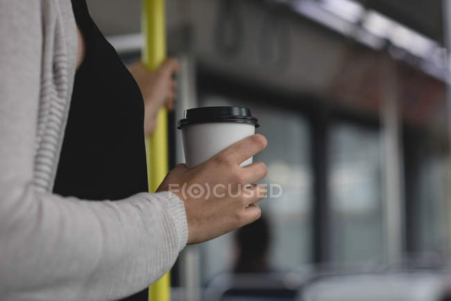 Parte média da mulher que toma café enquanto viaja de comboio — Fotografia de Stock
