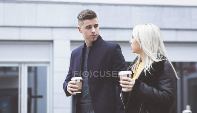 Jovem casal interagindo enquanto toma café — Fotografia de Stock