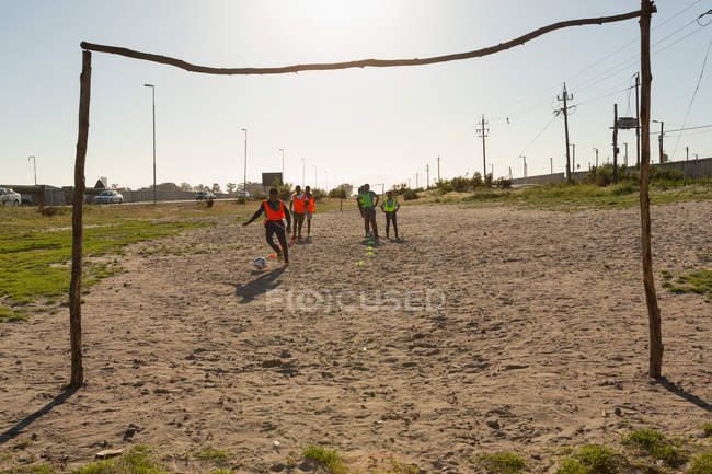 Kids playing football in the ground on a sunny day — Stock Photo