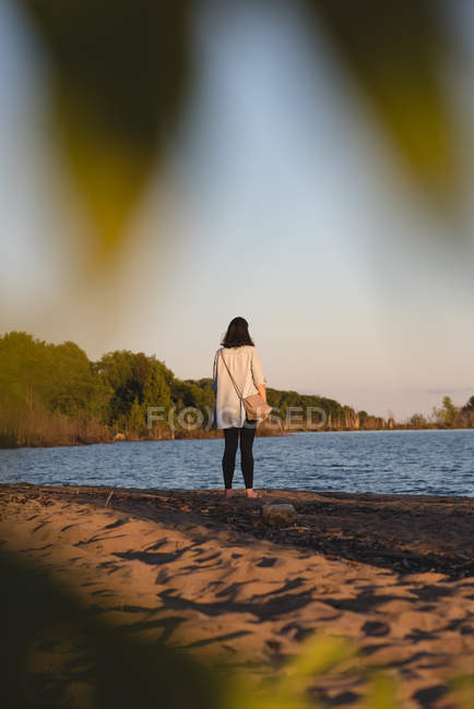 Задний вид женщины, стоящей на пляже — стоковое фото