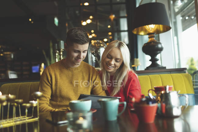 Happy couple discussing over menu card in cafe — Stock Photo