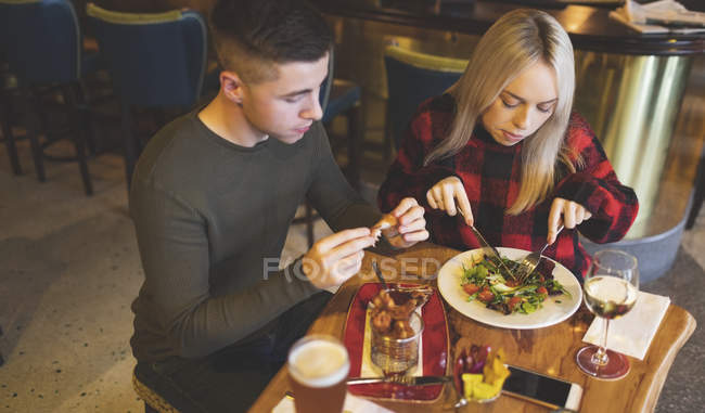 Casal jovem ter comida no restaurante — Fotografia de Stock