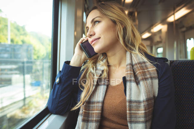 Mulher grávida bonita falando no telefone celular enquanto viaja no trem — Fotografia de Stock